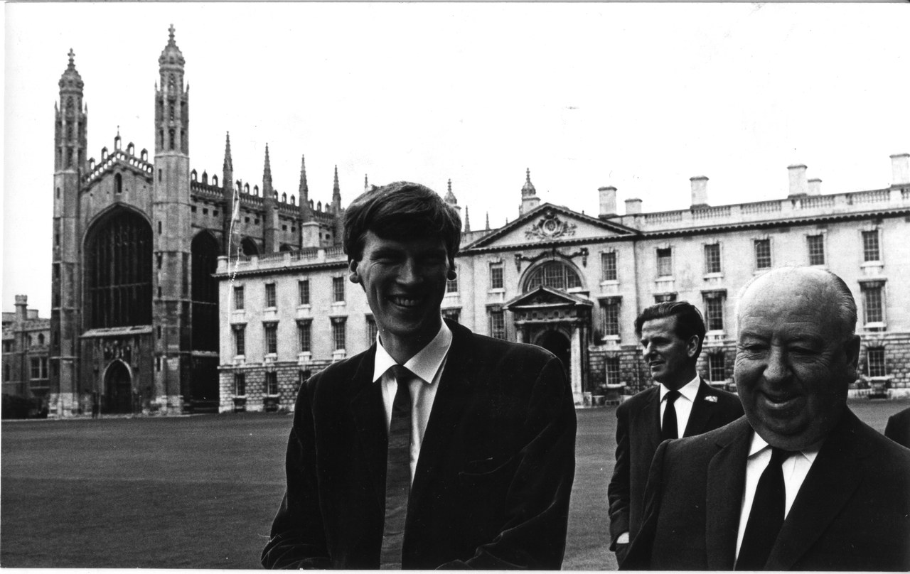 Dick Arnall and Alfred Hitchcock smiling on a lawn, with King's College Chapel and college buildings behind them